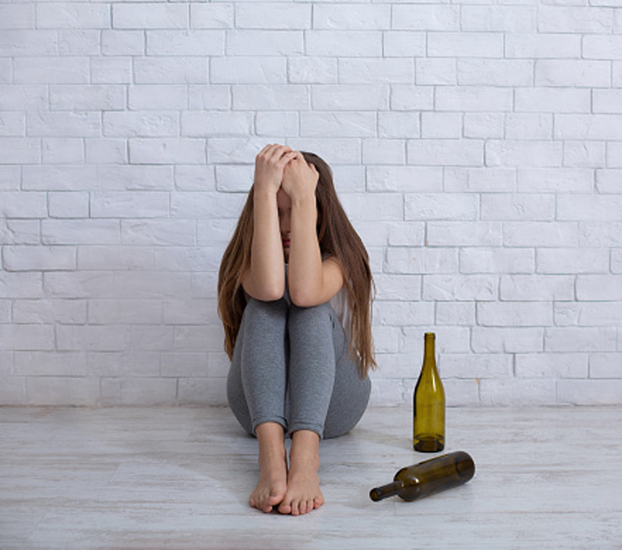 Молодая женщина-алкоголик пьет в одиночестве